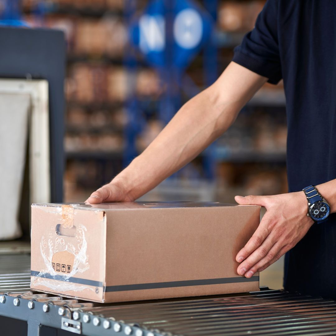 A person packing a box to ship