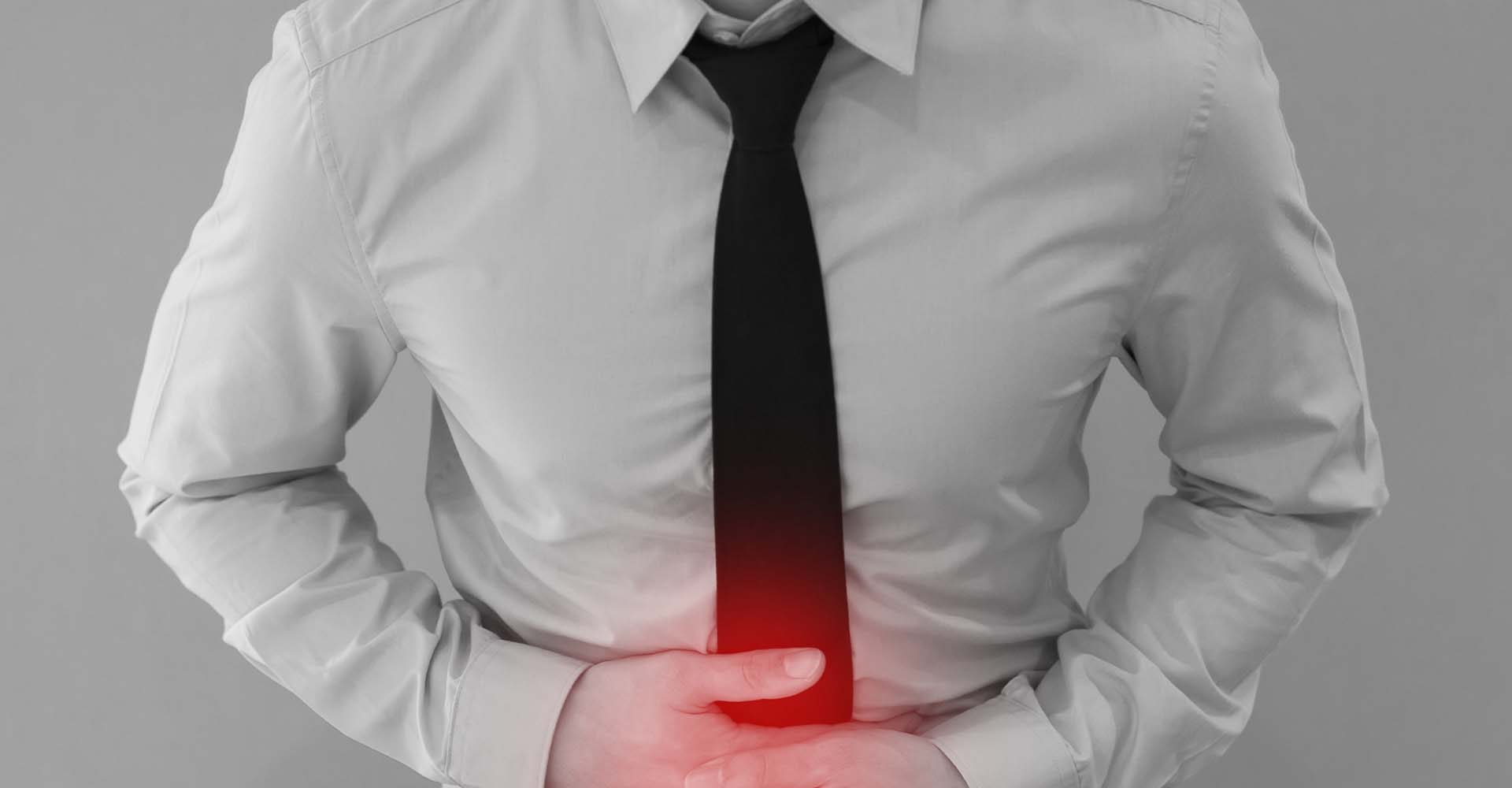 A man wearing a tie with stomach pain