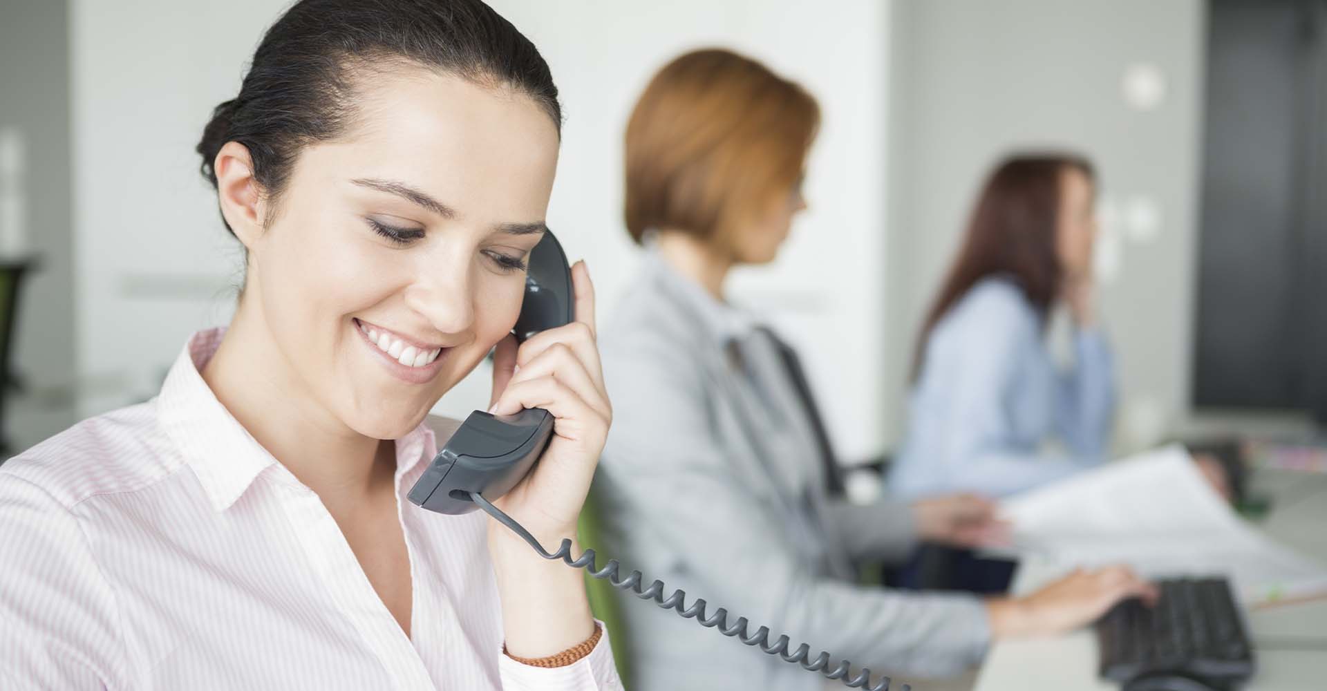 3 women in an office setting on the phone