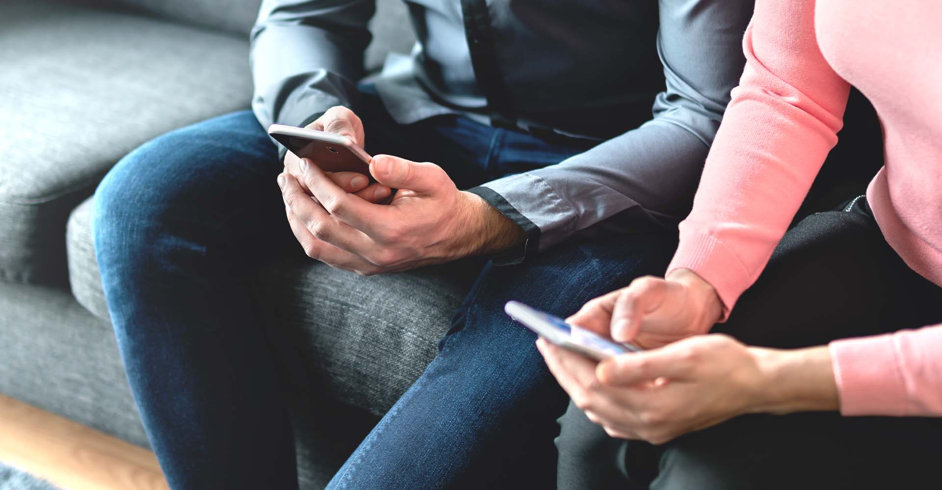 a couple on their phones on couch